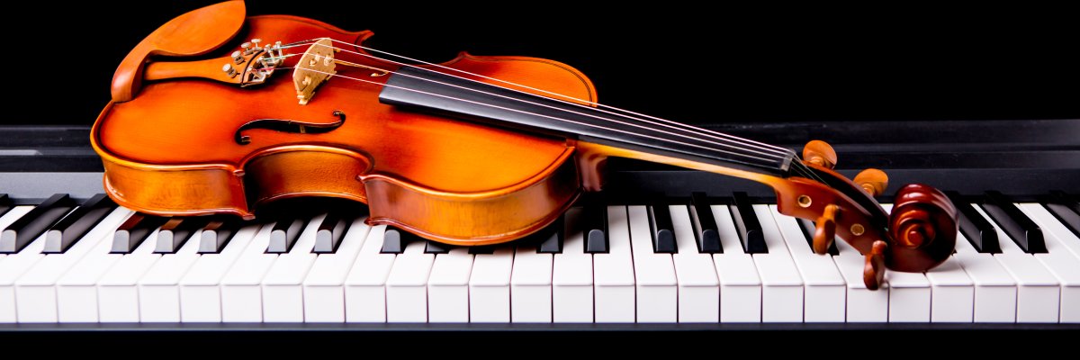 Violine auf einem Klavier vor einem schwarzen Hintergrund